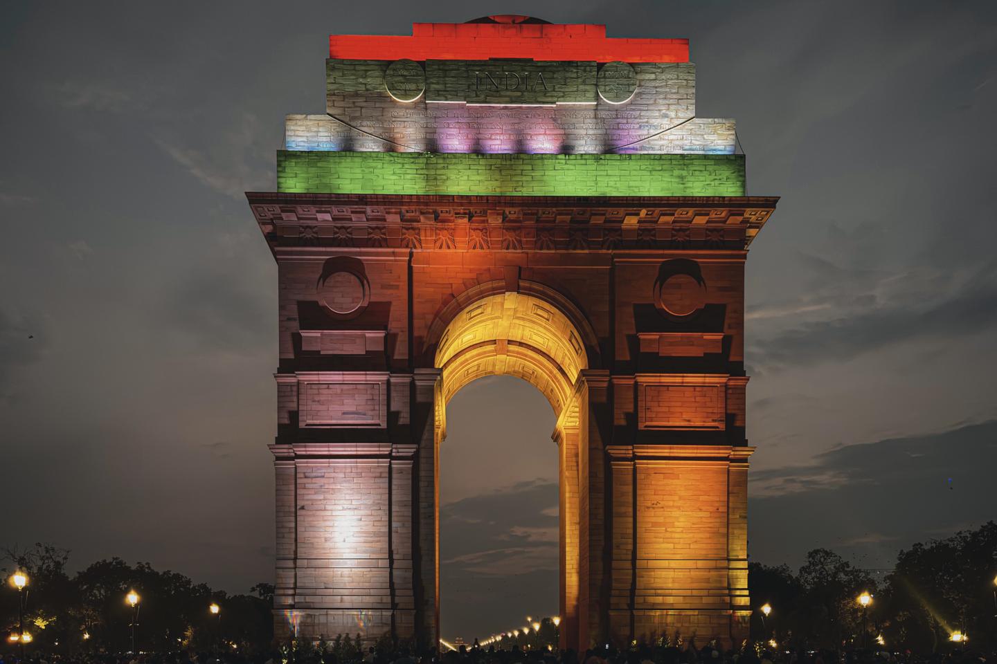India Gate illuminated in the colours of the Indian flag at night.