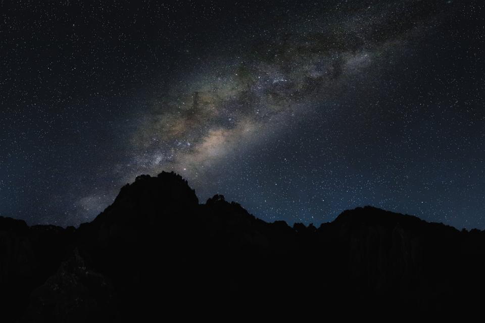 The Milky Way above a dark mountain ridge.
